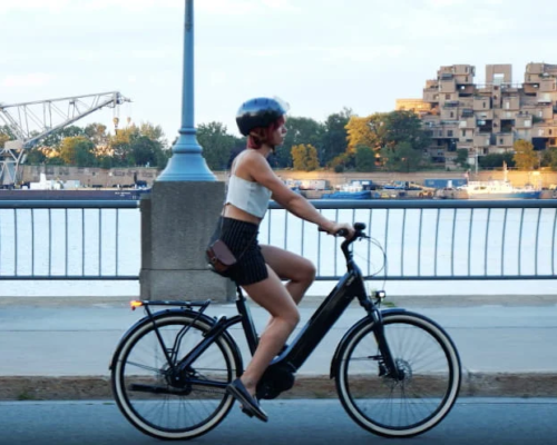 Une fille fait du vélo électrique pour femmes O2feel au bord de l'eau